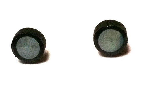 Two small, round Ohrstecker Kokosnuss weiß schwarz aus 925er Silber mit Perlmutt Muschel und Holzelementen liegen getrennt auf schlichtem weißem Hintergrund.